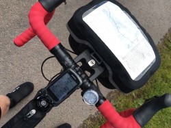 Road bicycle with red bar tape and handlebar bag with route map and notes
